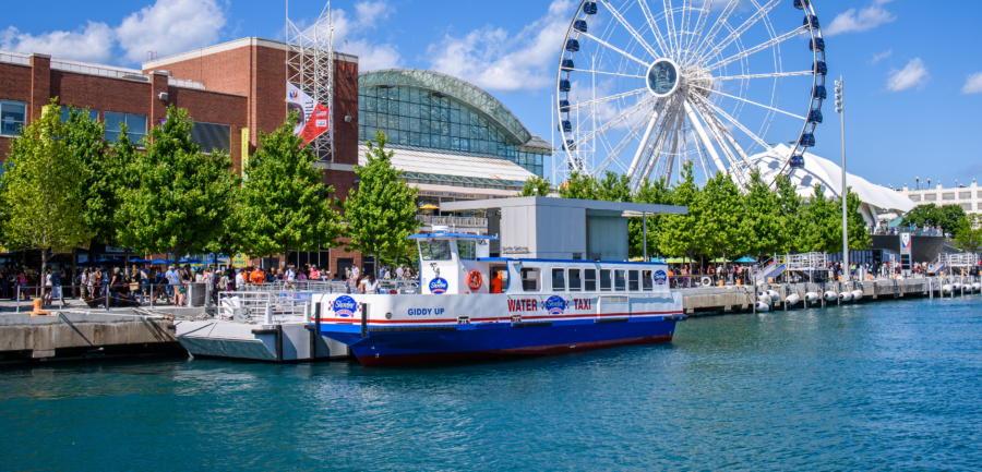 A boat docks at Navy Pier with a ferris wheel in the background.