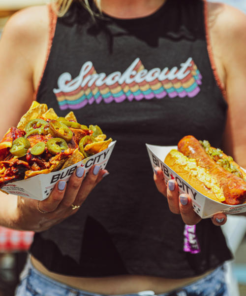A woman holds BBQ dishes at Windy City Smokeout