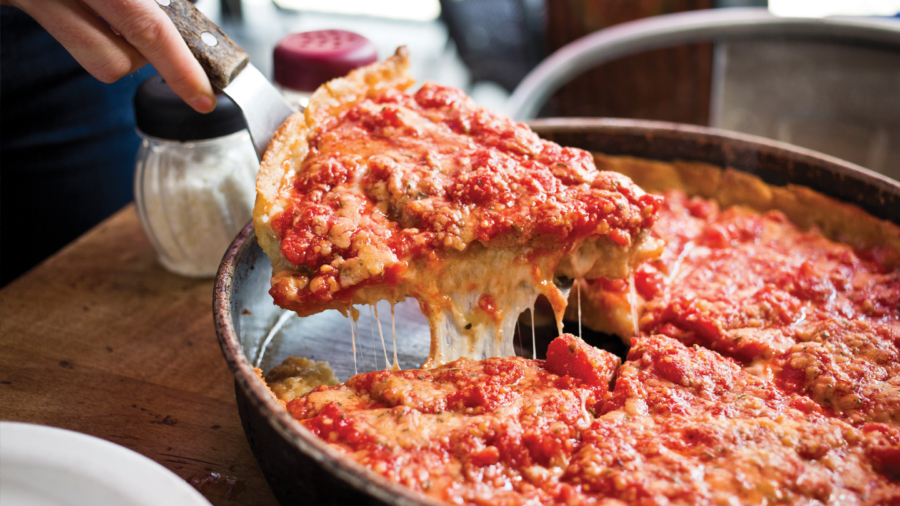 Person serving a slice of deep dish pizza in Chicago