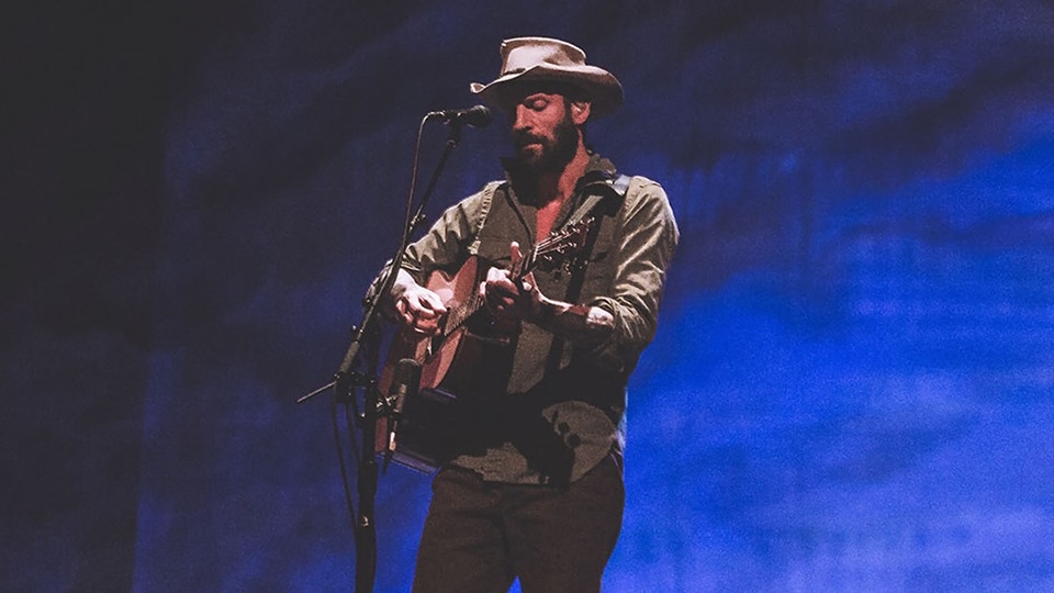 Ray LaMontagne playing guitar on stage for Just Passing Through tour