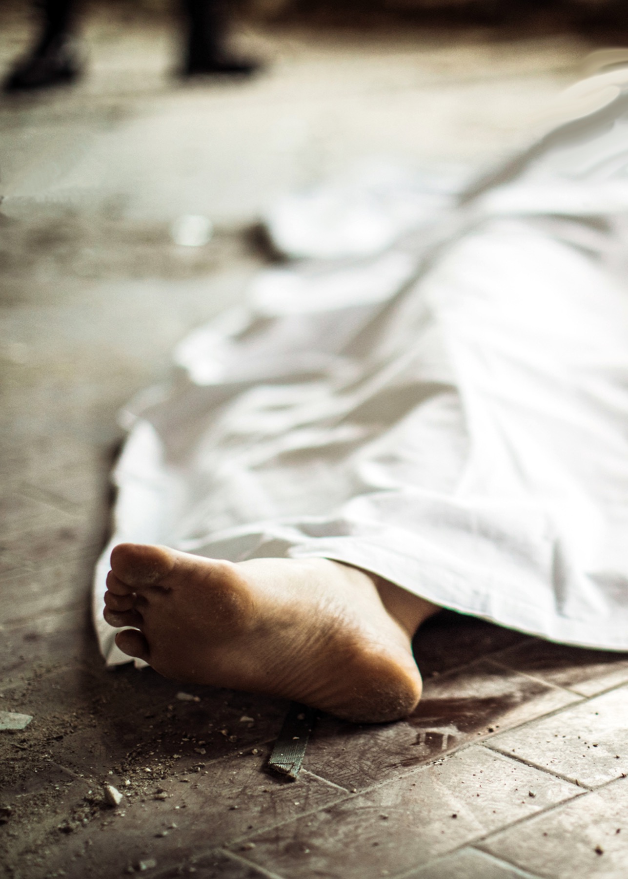 Person's foot exposed under a sheet