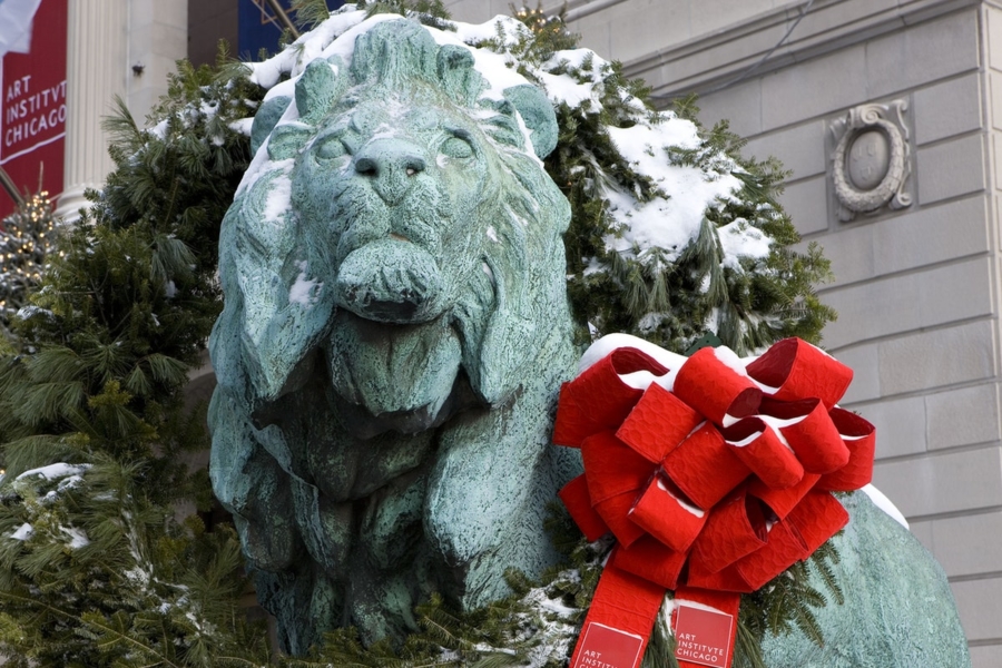 Snow-covered Lion statue with red bow at the Art Institute 