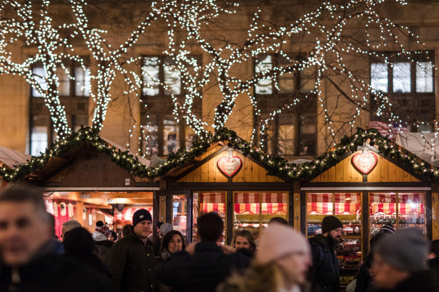 Christmas lights cover multiple trees on top of small buildings at the Christkindlmarket in Chicago.