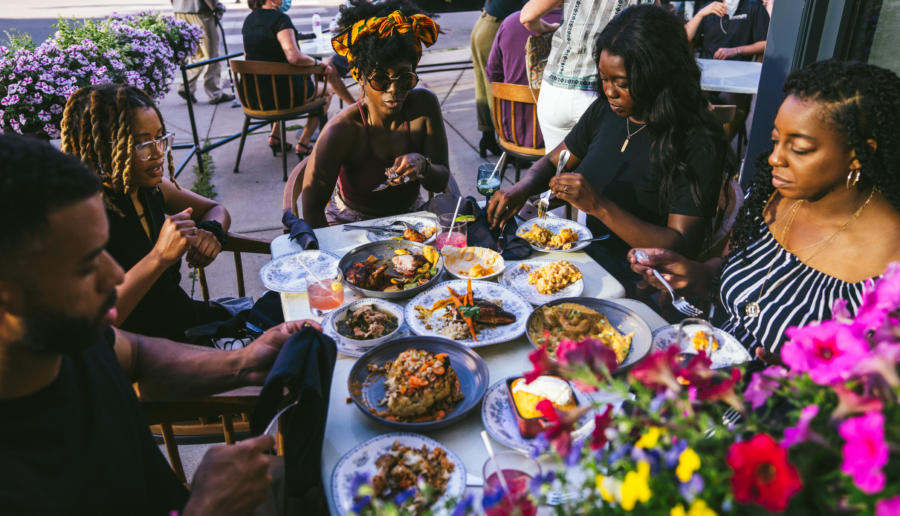 Friends dine on the patio at Virtue in Hyde Park