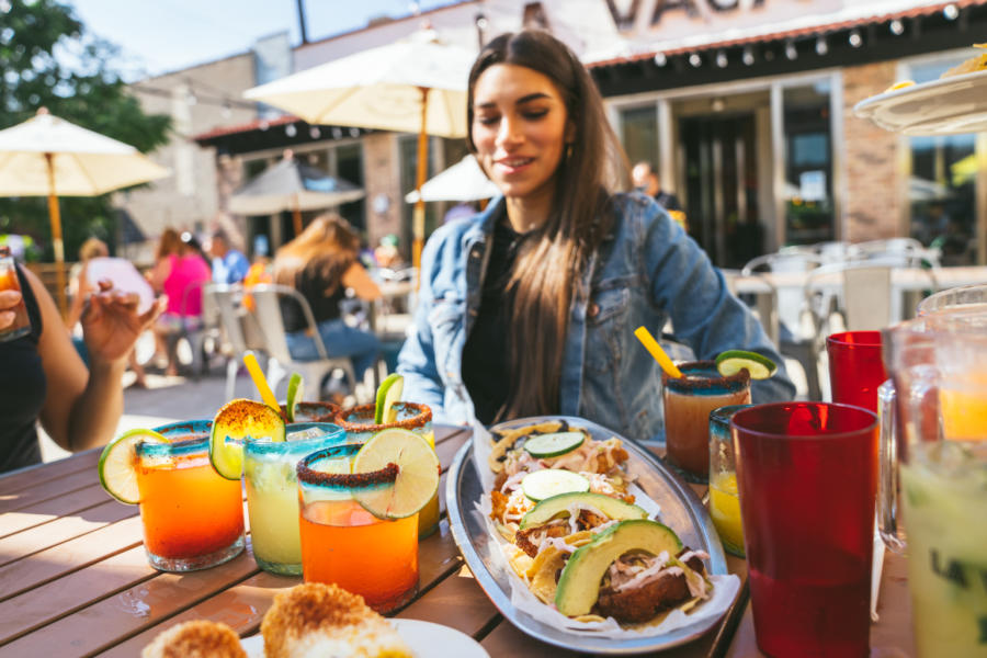 A woman drinks a margarita on the patio at La Vaca Margarita Bar