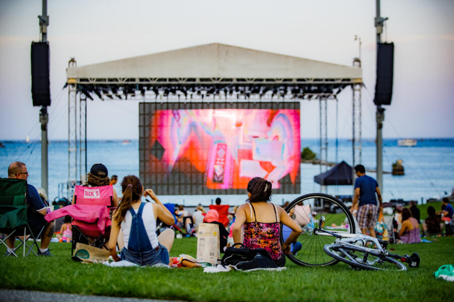 People watch a movie on the grass at Navy Pier