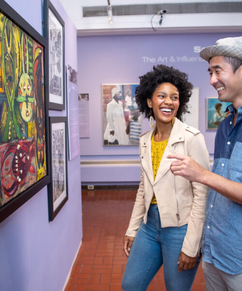 Two people view artwork inside The DuSable Black History Museum and Education Center