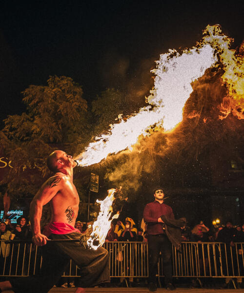 A performer blows fire from his mouth at night time at the Haunted Halsted Halloween event.