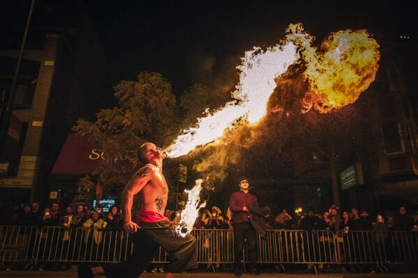 A performer blows fire from his mouth at night time at the Haunted Halsted Halloween event.