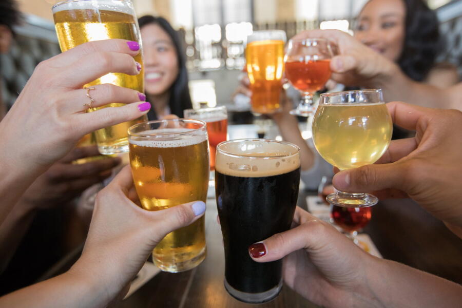 People raise their drink glasses during a toast inside ERIS Brewery and Cider House