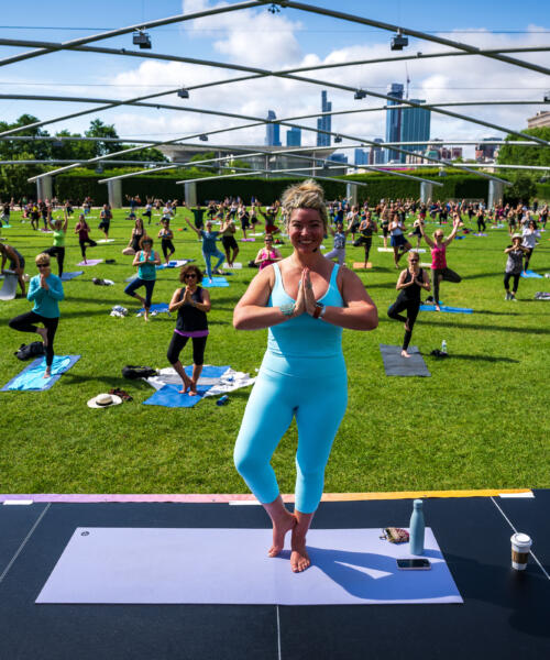 Residents doing yoga at Millennium Park Summer Workouts series at the Pritzker Pavilion in Chicago's Loop
