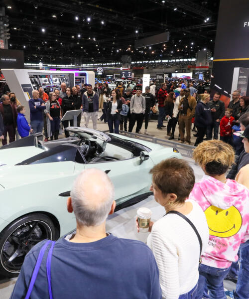 Crowds admire a car on display at the Chicago Auto Show