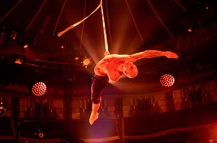 An acrobat soars through the air during Teatro ZinZanni