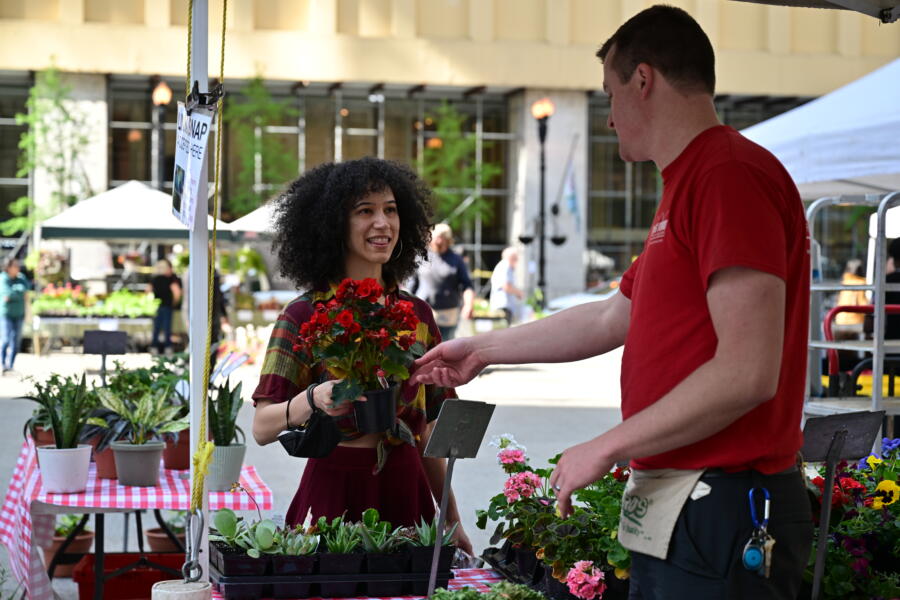 A woman buys flowers at the Daley Plaza Farmers Market