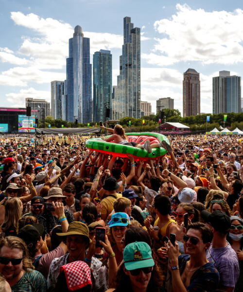 A festival goer crowd surfs on an inflatable watermelon slice at Lollapalooza