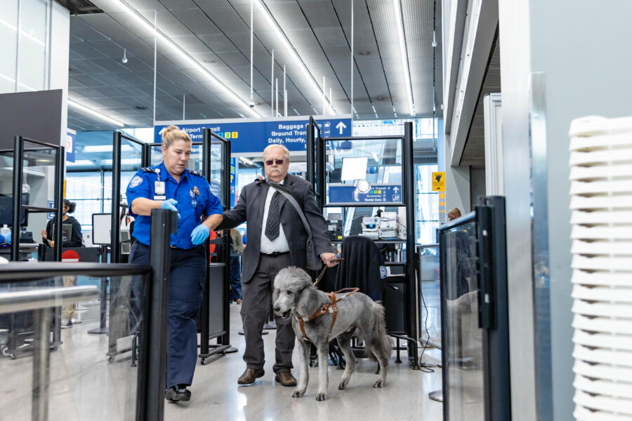 A man with a service dog navigates the airport