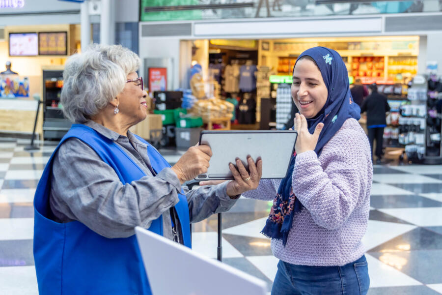 A women who is deaf communicates with an airline employee