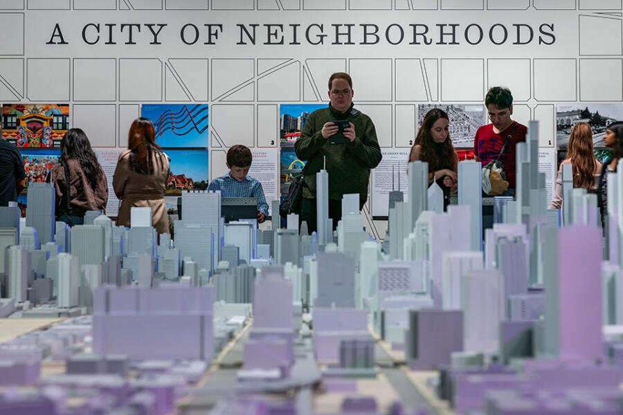 Visitors view a large scale model of Chicago's skyline at a 'A City of Neighborhoods' museum exhibit.
