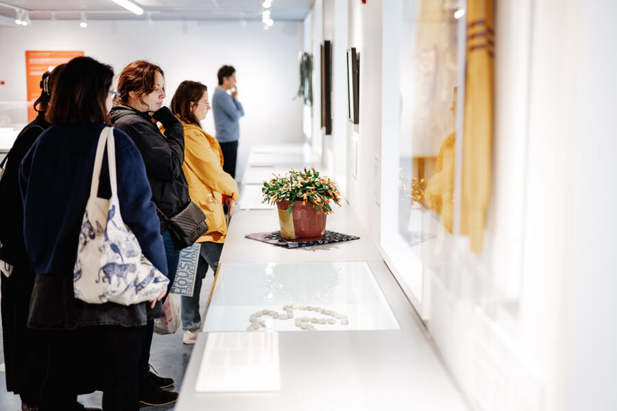 Five people stand next to a counter and look at exhibits at the Intuit Art Museum in Chicago