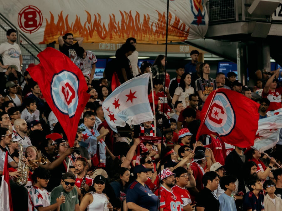 Chicago Fire fans at Soldier Field raise and wave flags in the sky to support and celebrate their team!