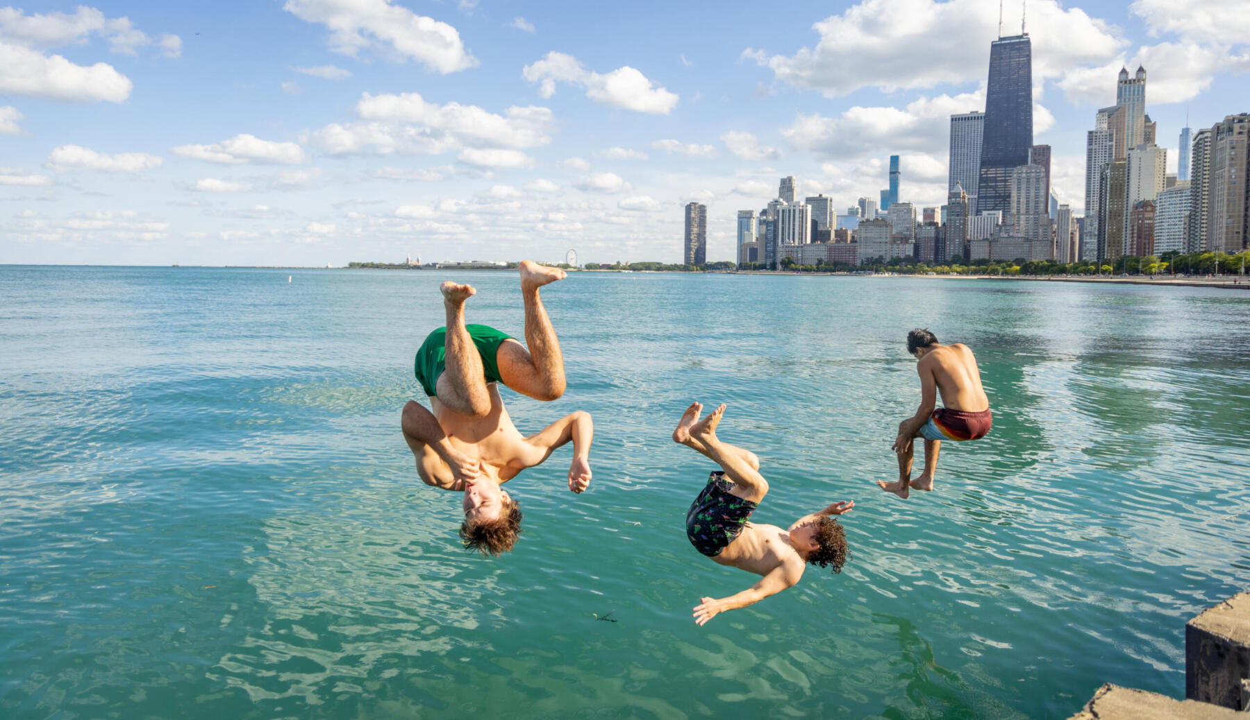 Friends jump in the water at North Avenue Beach