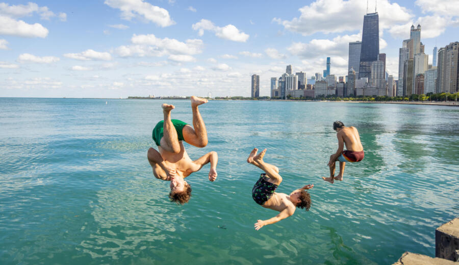 Friends jump in the water at North Avenue Beach