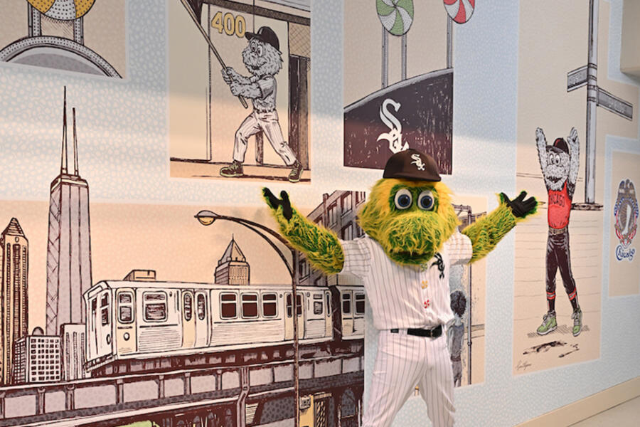 The Chicago White Sox mascot stands in front of the South Side Pride mural at Chicago Midway International Airport.