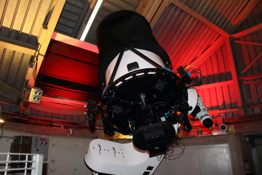 Large telescope inside the Adler Planetarium's Doane Observatory dome, lit in red.