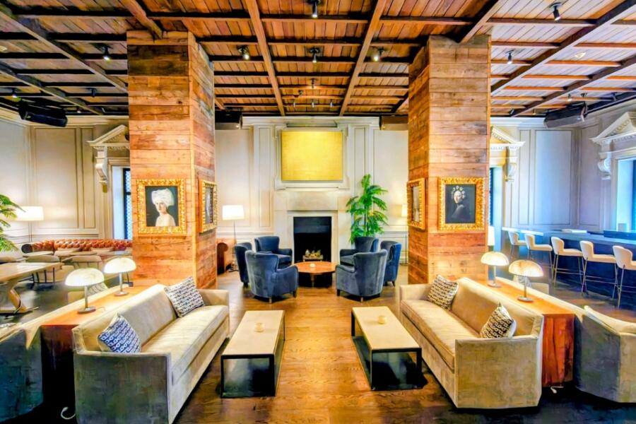 Elegant hotel lounge with lounge seating, a fireplace, and a bar along the side.