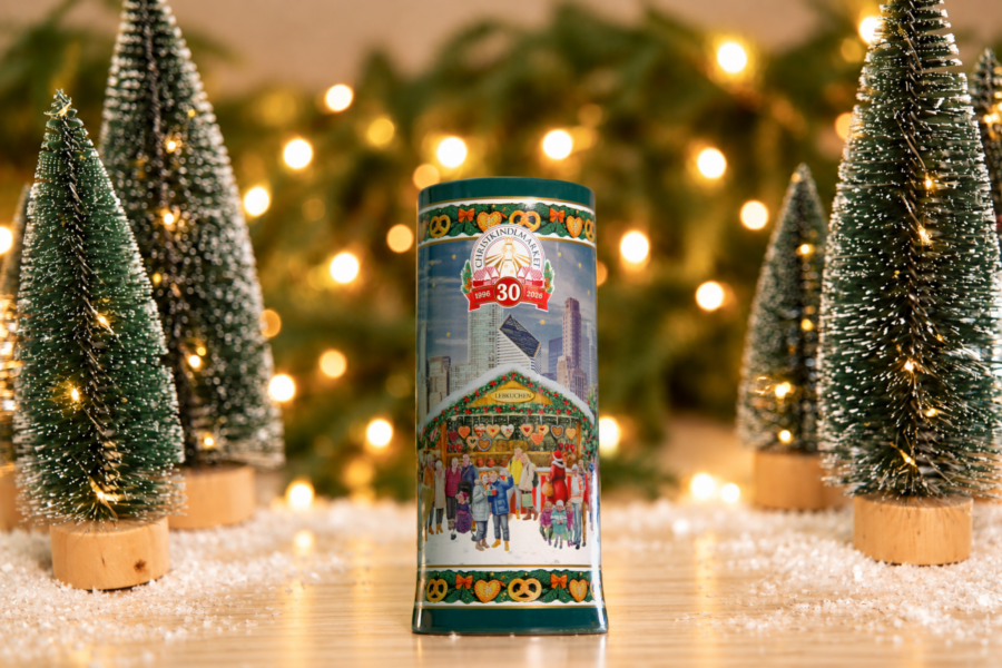 The Christkindlmarket 30th Anniversary Beer Stein placed next to small Christmas trees.