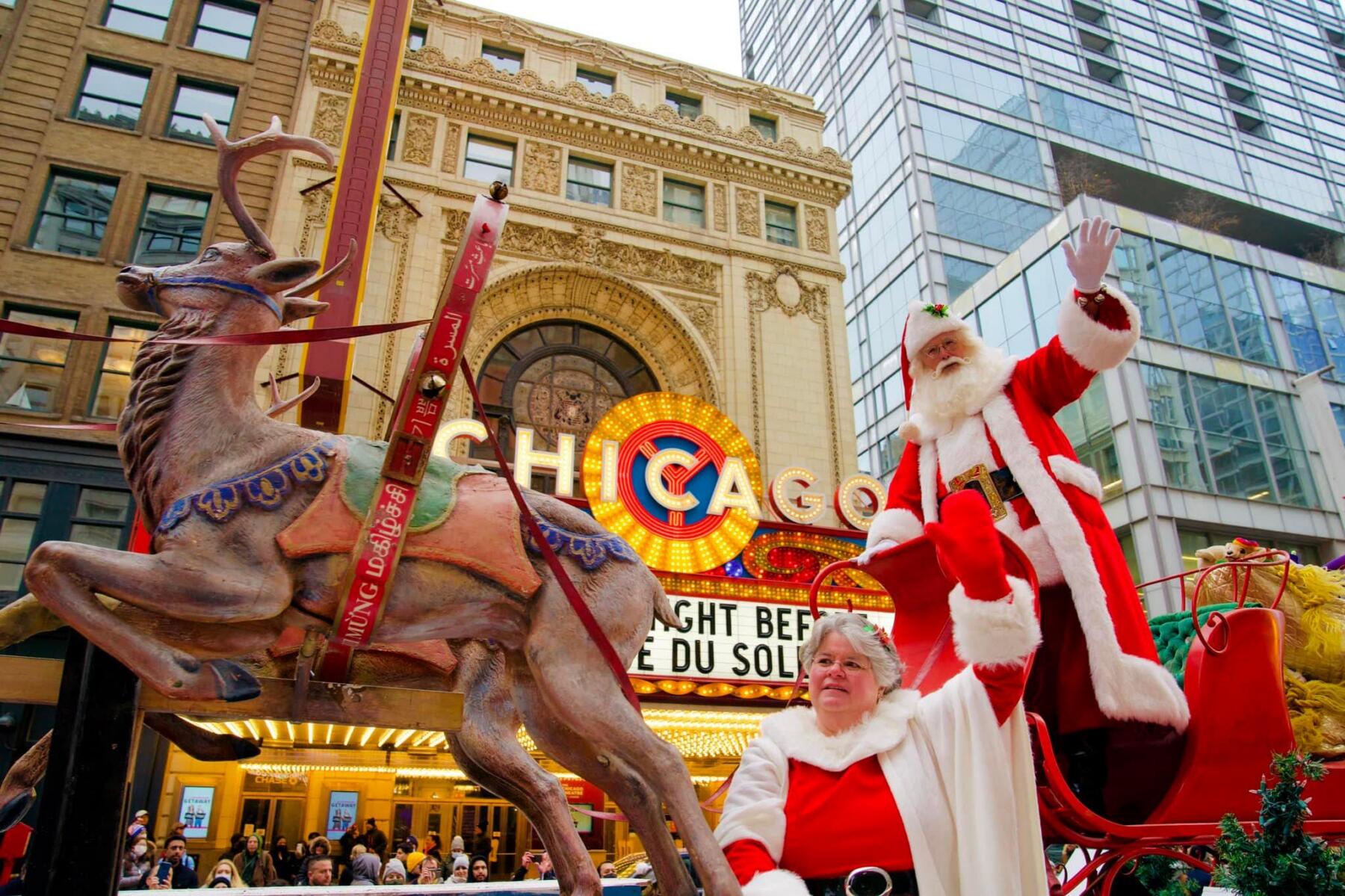 A man and woman dressed as Santa and Mrs. Claus, respectively, wave at the crowd during the Chicago Thanksgiving Parade.